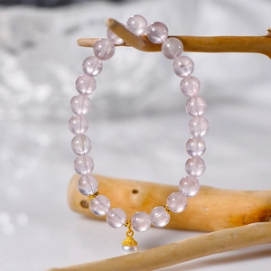 8mm natural rose quartz beaded bracelet with a pearl pendant on a wooden branch