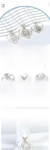 Detail of handcrafted wire-wrapped heart pendant with natural clear crystal stone