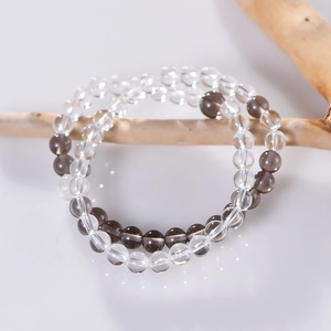 Bracelet double couche en quartz blanc et fumé naturel sur un support en bois