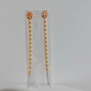 Detail van rood-witte kerstzuurstok met kralen en een spiraalvormige lolly aan de top
