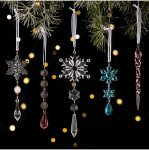 Clear acrylic snowflake and icicle Christmas ornaments with silk ribbons on pine branches