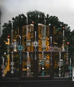 Detailed view of clear acrylic snowflake and icicle ornaments hanging on a Christmas tree