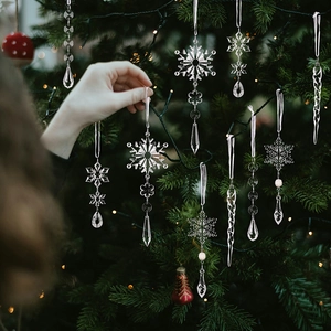 Close-up of acrylic snowflake and icicle ornaments hanging on a Christmas tree
