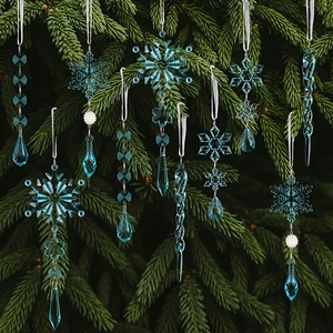 Detail of light blue acrylic snowflake and icicle ornaments hanging on a green pine tree