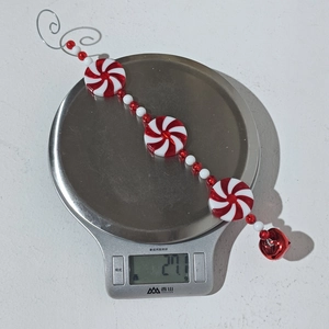 Macro di decorazione natalizia a perline bianche e rosse con campanellino festivo