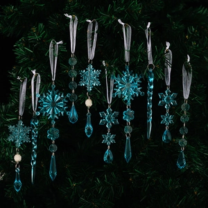 Close-up of icy blue acrylic snowflake and icicle ornaments hanging on a Christmas tree