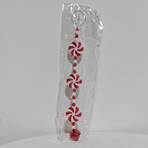 Dettaglio di perline a bastoncino bianche e rosse con campanellino per l'albero di Natale