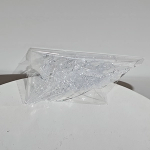 Macro shot of bulk clear acrylic crushed ice crystals in a transparent plastic bag