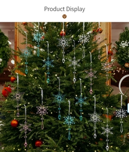 Detail of transparent snowflake and icicle ornaments hanging on a lighted Christmas tree
