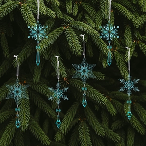 Detail of blue crystal snowflakes with teardrop beads hanging on green pine tree branches