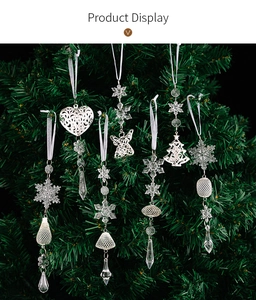 Gros plan d'ornements de flocons et d'anges en acrylique sur une branche de sapin