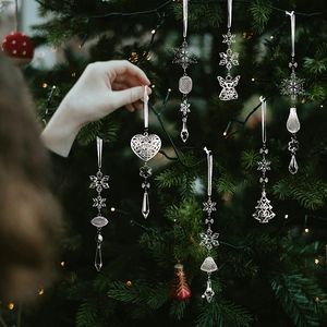 Détail de décorations de Noël en métal argenté avec pendentifs cristal sur sapin