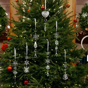 Vue détaillée de breloques en cristal acrylique et métal argenté sur un sapin de Noël