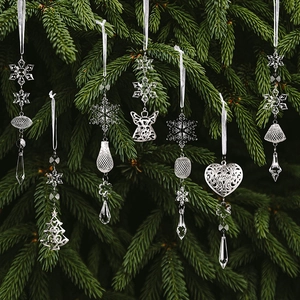Détail de flocons en acrylique et anges en argent suspendus à un sapin de Noël vert