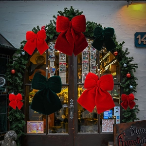 Detailed view of red and green velvet Christmas bows in various sizes for festive decor