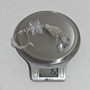 Vue macro d'un pendentif flocon en acrylique sur une balance pesant 15,2 grammes