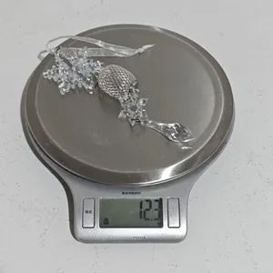 Vue détaillée d'une décoration flocon en acrylique pesant 12,3 grammes sur une balance