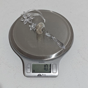 Détail macro d'un ornement de flocon en acrylique pesant 10,1g sur une balance de cuisine