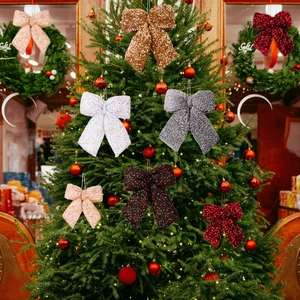 Glittering sequin Christmas bows hanging on a festive tree with warm lights decoration