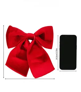 Red velvet Christmas bow 21x23cm size comparison with a phone for scale and dimensions