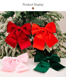Macro shot of multi-colored velvet Christmas bows hanging on a snowy festive tree