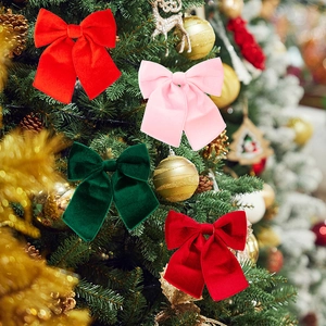 Detailed view of plush red and green velvet Christmas tree bows with hanging ornaments