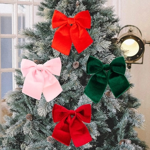 Set of four large velvet Christmas bows in red and green for festive tree decoration