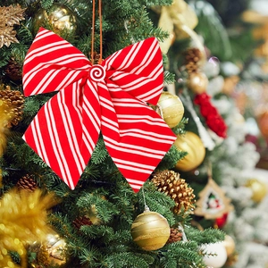 Detail of red and white striped Christmas bow with peppermint candy center on festive tree
