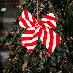 Detail of red white striped Christmas bow with candy center on a decorated festive tree
