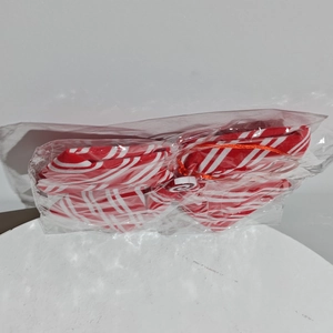 Detail of red and white striped Christmas bow ornament with swirl center in packaging