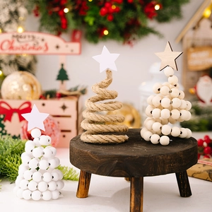 Détail de mini sapins de Noël nordiques en perles de bois avec étoiles sur table rustique