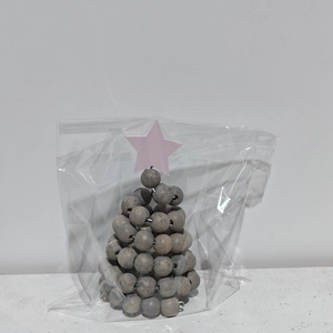 Détail d'un sapin de Noël nordique en perles de bois dans un emballage de protection