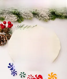 Close-up of colorful peppermint candy ornaments on a white plate with Christmas decor