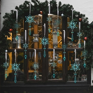 Set of 15 cyan acrylic snowflake ornaments with silver ribbons on a rustic window frame