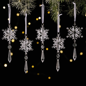 Macro shot of 5pcs clear crystal snowflake pendants with icicles hanging on pine branches