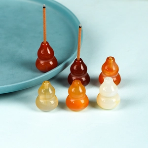 Translucent gourd-shaped agate incense holders set on a refreshing light blue background
