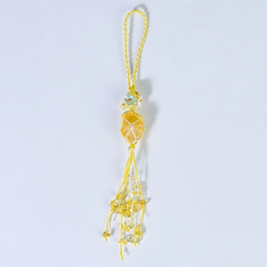 Handmade woven keychain featuring raw yellow crystal stone with beaded fringe details