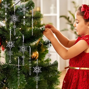 Detail von klaren Acryl-Schneeflocken und Eiszapfen-Anhängern an einem Weihnachtsbaum
