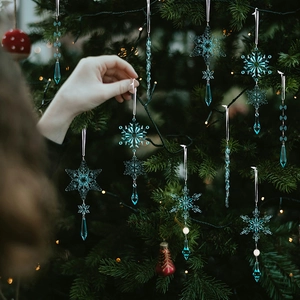 Detailansicht von blauen Acryl-Eiszapfen und Schneeflocken am Weihnachtsbaum