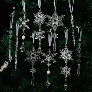 Nahaufnahme klarer Acryl-Schneeflocken und Eiszapfen-Anhänger an einem Weihnachtsbaum