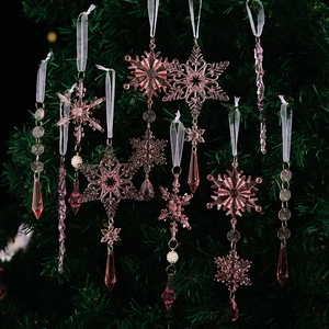 Rosa Acryl-Eiszapfen und Schneeflocken-Anhänger an einem grünen Weihnachtsbaum hängend