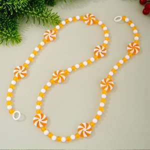 Detail of Christmas candy garland with orange swirl peppermint beads and tassels