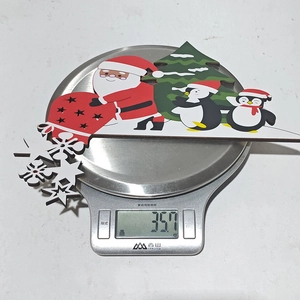 Macro shot of a wooden Santa Claus ornament on a digital scale showing 35.7g weight