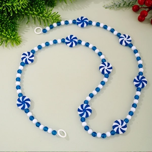 Close-up of blue and white peppermint candy beads with festive wooden pearls on a string