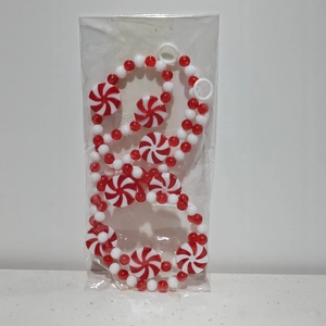 Detail of red and white Christmas peppermint bead garland with candy discs in clear packaging