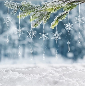Clear acrylic Christmas icicle and snowflake ornaments hanging on snowy pine branches