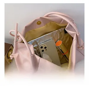 Vista interior del bolso tote rosa que muestra espacio para móvil y tabletas