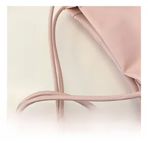Primer plano del bolso tote rosa con detalles de correa de hombro redonda y cuero