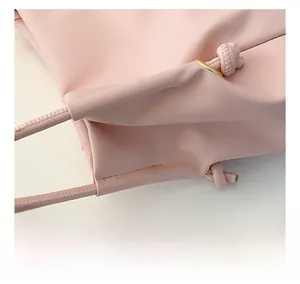 Detalle del bolso de cuero rosa con costura de calidad y cordón con anillo dorado