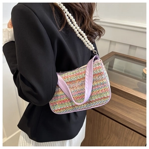 Détail d'un sac au crochet à rayures colorées avec broderie papillon et chaîne perles